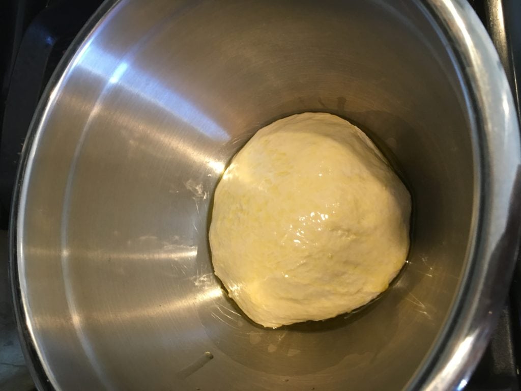 heart shaped pizza dough in oiled bowl